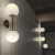 Aplique de pared Barral de 2 luces con esferas de vidrio opalino, perfecto para iluminar espacios interiores.