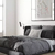 Aplique de pared Cavia en una habitación moderna con cama y decoración en tonos grises.