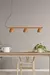 Colgante TEO de tres pantallas, con lámparas de color terracota, instalado sobre una mesa de madera clara en un ambiente moderno y minimalista.