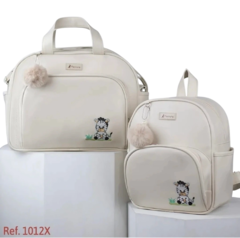 Conjunto de bolsas em tom bege com estampa de tigre, uma bolsa de mão e uma mochila, ambas com detalhes em pompom.
