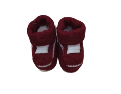 Sapatinho vermelho para recém-nascidos, com detalhes brancos, ideal para momentos de brincadeira e conforto.