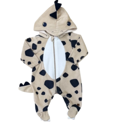 Macacão de bebê em formato de dinossauro, com capuz e estampa de manchas pretas sobre fundo claro.