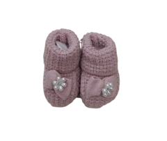 Sapatinho de bebê rosa com laço e detalhe de pérolas.
