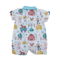 Macacão infantil com estampa de fazenda, incluindo galinhas, cavalos e celeiros, na cor branca com detalhes em azul.