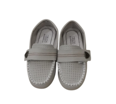 Imagem de um par de sapatos Klin em tom marfim, com detalhes de costura branca e tira de velcro na parte superior.