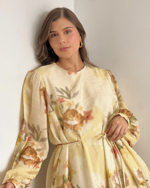 Detalle frontal del vestido floral T.168 de PRIMIA, mostrando el escote redondo, las mangas abullonadas y el cordón para ajustar la cintura.