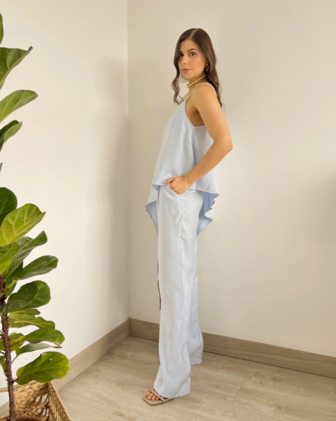 Set T.203 Azul de PRIMIA, vista lateral de cuerpo completo mostrando el top de silueta suelta, largo asimétrico y pantalón con bolsillos.