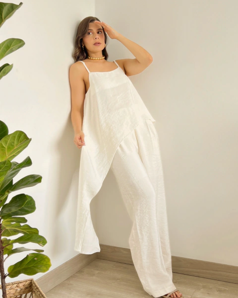 Conjunto de dos piezas T.203 Blanco de PRIMIA, vista frontal de cuerpo completo con top asimétrico de caída larga y pantalón ancho.