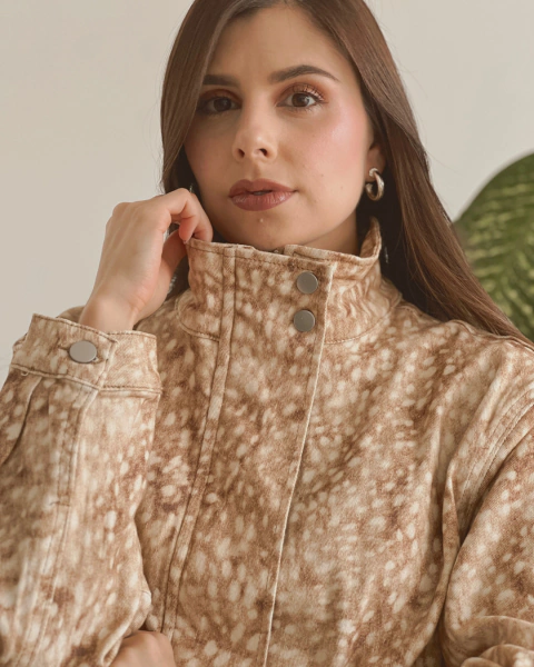 Chaqueta Bambi Lucce de PRIMIA con cuello alto y bolsillos laterales, combinada con pantalón blanco.