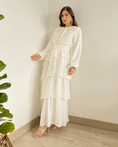 Vestido Blanco T.153 de PRIMIA, vista frontal de cuerpo completo con silueta fluida, mangas voluminosas y falda de volantes superpuestos.