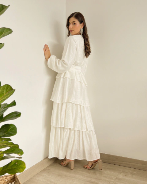 Vestido T.153 Blanco de PRIMIA, vista posterior de cuerpo completo con mangas largas, cintura ajustada y falda larga de volantes en niveles.