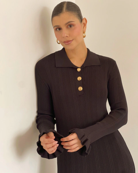 Primer plano del vestido T.202 negro de PRIMIA con cuello tipo polo, tres botones dorados y textura acanalada.
