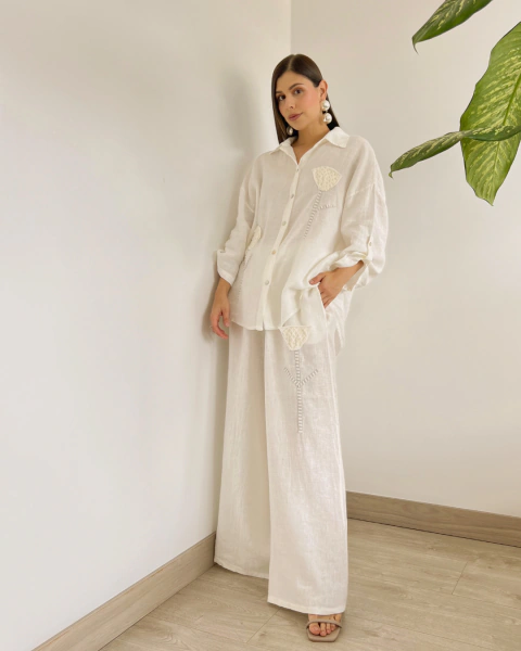 Set 96483 Blanco de PRIMIA, vista de tres cuartos del conjunto con camisa blanca de corte relajado y pantalón de pierna ancha con detalle floral.