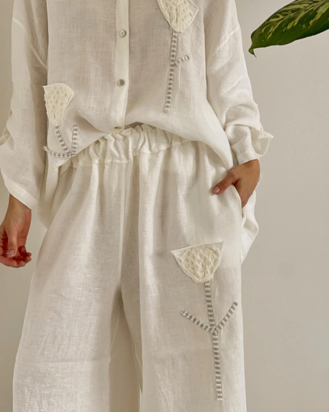 Set 96483 Blanco de PRIMIA, detalle frontal del pantalón con cintura fruncida, bolsillo lateral y aplique floral blanco en relieve.