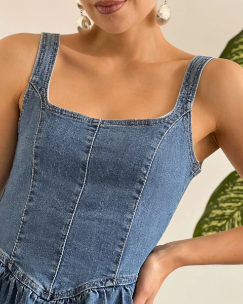 Detalle frontal del vestido denim T.174 de PRIMIA con escote cuadrado, tirantes anchos y costuras verticales.