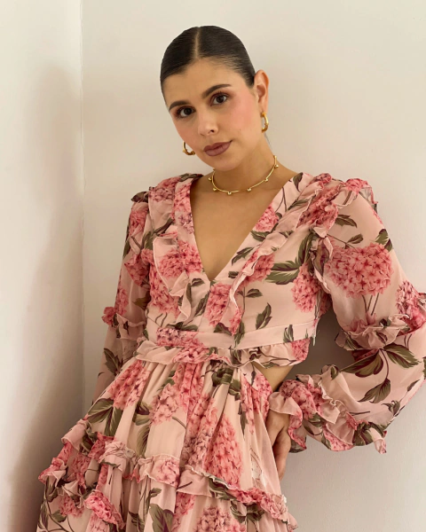 Detalle frontal del vestido T.173 de PRIMIA, con estampado floral, escote profundo en V y volantes.