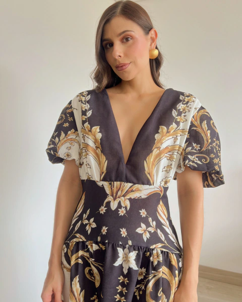 Vestido T.146 de PRIMIA, detalle frontal del escote en V profundo, mangas cortas amplias y estampado de flores y hojas ornamentales.