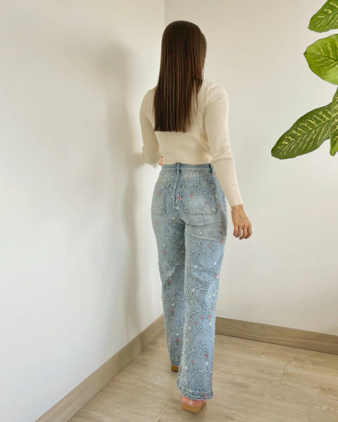 Jean NOHELA Azul de PRIMIA, vista posterior de cuerpo completo que muestra los bolsillos traseros, los bordados florales y el corte de pierna recta.