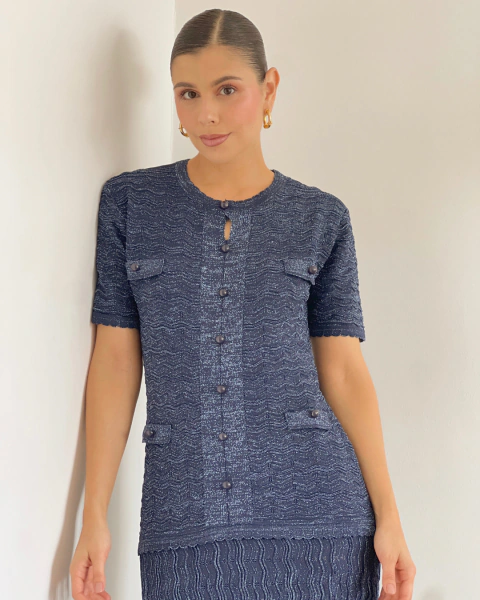 Vista frontal del vestido tejido T.212 Azul de PRIMIA, con botones tono sobre tono y cuatro detalles tipo bolsillo con solapa.