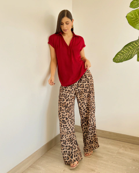 Blusa Noa Roja de PRIMIA, vista frontal de cuerpo completo combinada con pantalón de estampado animal print, que muestra su caída suelta y largo a la cadera.