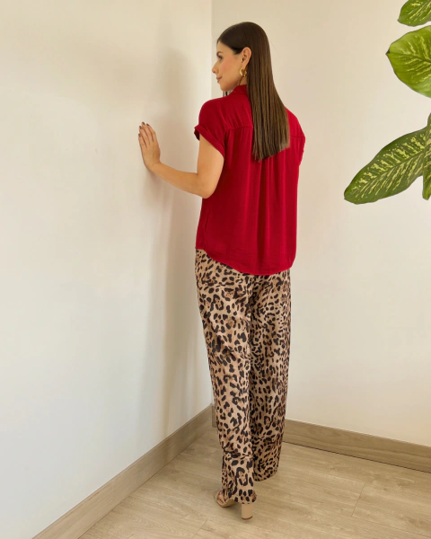 Blusa Noa Roja de PRIMIA, vista posterior de perfil que destaca la caída suelta, las mangas cortas dobladas y el largo de la blusa sobre la cadera.
