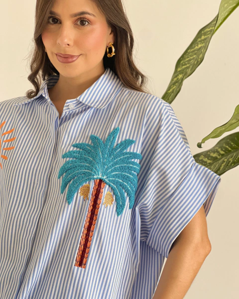 Primer plano del Blusón P.082 de PRIMIA, mostrando el cuello camisero, las rayas verticales y la aplicación de palmera turquesa.