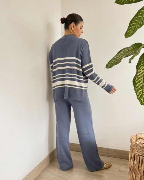 Conjunto azul de PRIMIA, vista posterior de cuerpo completo con buzo de rayas blancas horizontales, hombros caídos y pantalón de pierna ancha.