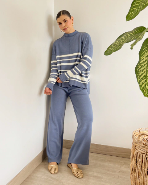 Conjunto azul de PRIMIA, vista frontal de cuerpo completo con buzo de rayas blancas, mangas largas y pantalón de tiro alto y pierna ancha.