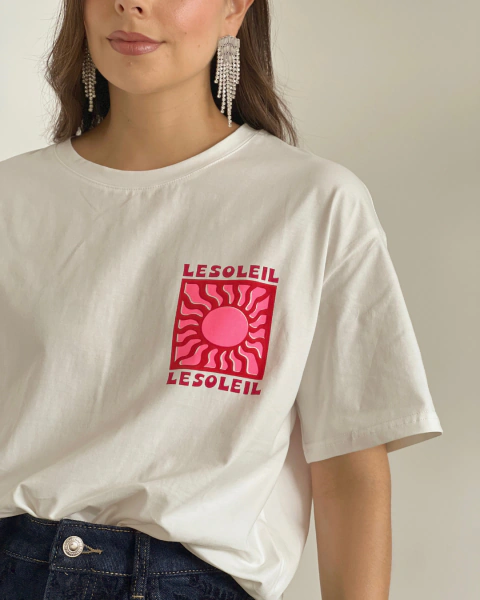 Detalle frontal de la Camiseta P.084 de PRIMIA, con cuello redondo, manga corta y estampado LESOLEIL en tonos rosados y fucsias.