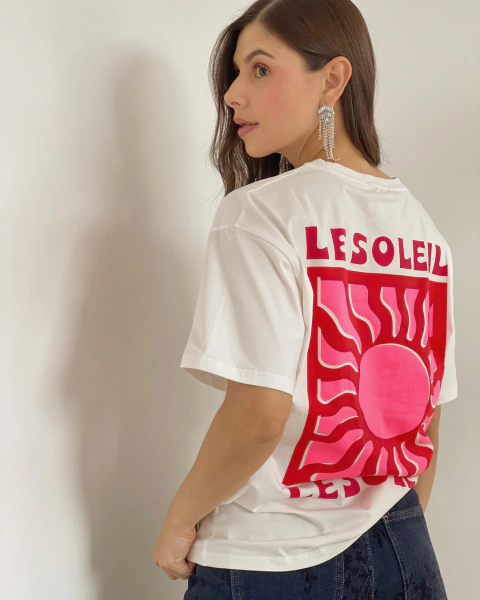 Camiseta blanca P.084 de PRIMIA, vista posterior en primer plano con diseño gráfico de sol rosado, fondo fucsia y texto LESOLEIL.