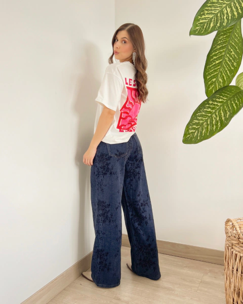 Camiseta P.084 de PRIMIA, vista posterior de cuerpo completo con estampado LESOLEIL de gran formato en tonos rosados y fucsias.