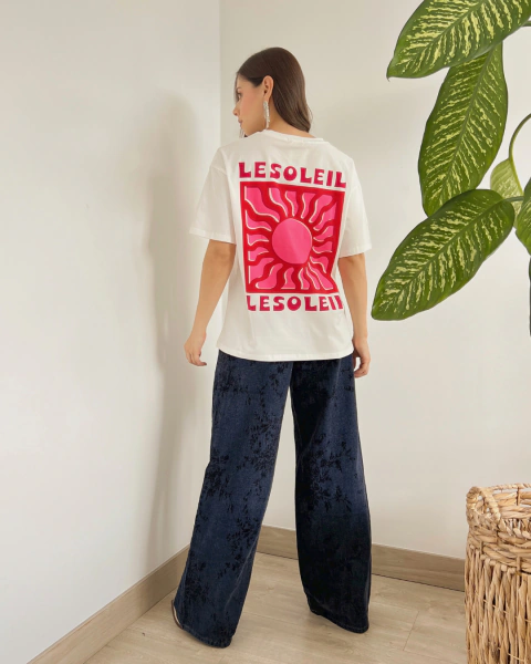 Camiseta blanca P.084 de PRIMIA, vista posterior de cuerpo completo con estampado grande de sol rosado y fucsia y texto LESOLEIL.