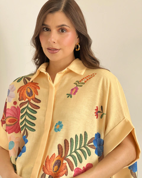 Primer plano frontal del Blusón Floral P.086 Amarillo de PRIMIA, con cuello camisero, manga corta amplia y motivos florales multicolor.