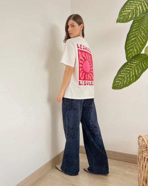 Camiseta blanca P.084 de PRIMIA, vista posterior lateral con estampado de sol rosado y fucsia y texto LESOLEIL.