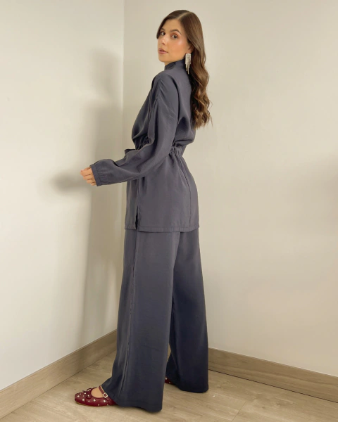 Set T.152 Azul Oscuro de PRIMIA, vista lateral de cuerpo completo mostrando la blusa de manga larga, la cintura ajustada y el pantalón amplio.
