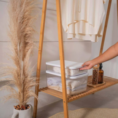 Caixa organizadora canelada com tampa, sendo utilizada em ambiente decorativo, ao lado de uma planta e itens de decoração.