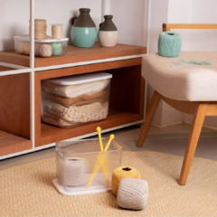 Caixa organizadora canelada com tampa em ambiente decorativo, ao lado de novelos de linha e utensílios para artesanato.