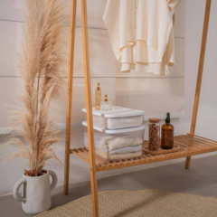 Caixa organizadora canelada com tampa, ideal para organização de ambientes, posicionada em uma prateleira ao lado de itens decorativos.
