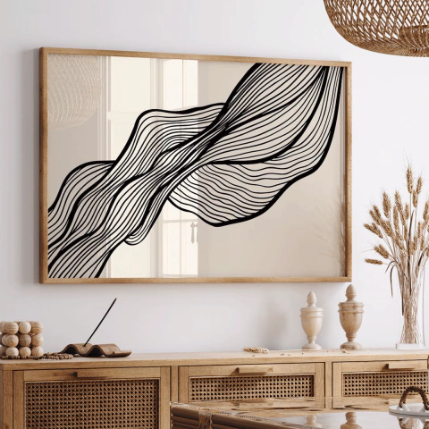 Cuadro horizontal con líneas negras onduladas en movimiento sobre fondo claro enmarcado en madera, decorando un ambiente con muebles y objetos de madera natural