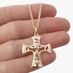 Colar folheado ouro com crucifixo detalhado em uma mão