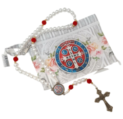 Terço São Bento em pérolas com bolsinha branca e detalhes florais, incluindo um crucifixo prateado.