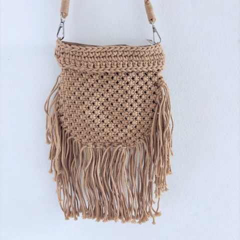 Bolsa lateral caramelo com franjas, feita em cordão trançado, alça dupla trançada e fechamento com zíper. Moderna, estilosa e prática para o dia a dia.

