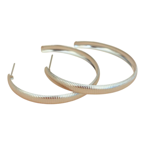 Argola média em aço inox hipoalergênico, com delicados riscos na superfície e fecho de tarracha. Brinco leve, resistente e perfeito para o uso diário.