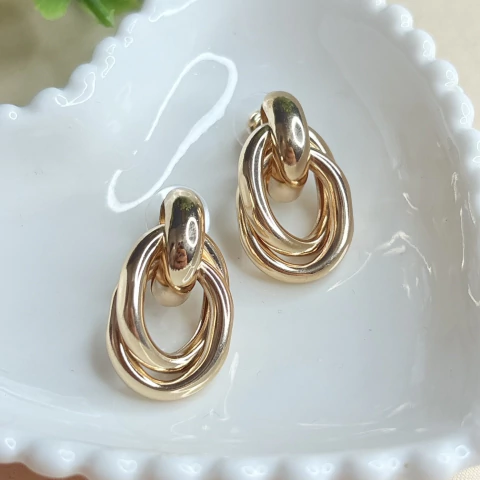 Brinco de elos entrelaçados em metal dourado com 2,9 cm. Moderno e sofisticado, ideal para looks elegantes e versáteis. Leve e confortável.