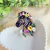 Broche de zebra com flores coloridas e aplicação de pedras brilhantes. Um acessório criativo, elegante e cheio de personalidade para dar vida aos seus looks.