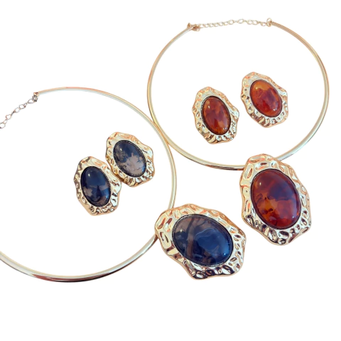 Colar de aro dourado com pedra grande pendurada, envolta em metal dourado. Acompanha brinco combinando. Disponível em vermelho, marrom, caramelo ou preto.