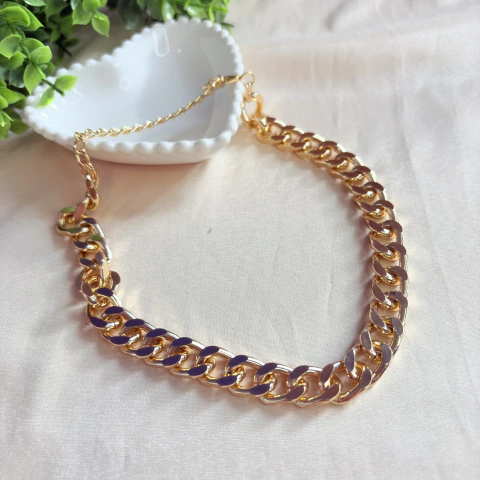Colar de corrente curta dourada com elos lisos semi quadrados. Um acessório moderno e versátil para compor looks elegantes e atemporais.

