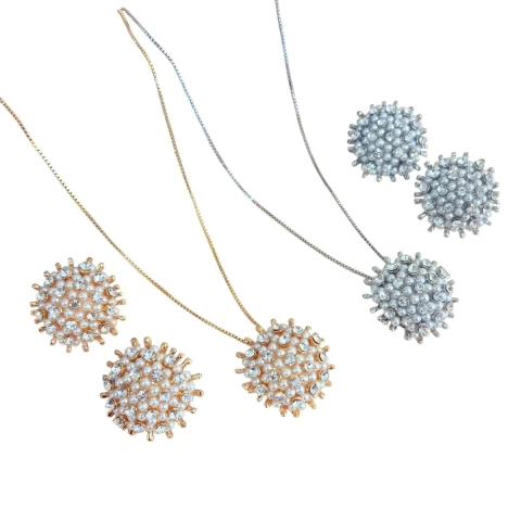 Conjunto com colar de corrente fina e pingente redondo coberto por pedrinhas e pérolas. Base prateada ou dourada, acompanha brinco combinando. Ideal para festas, casamentos e formaturas.