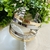 Pulseira bicolor em metal com design moderno, exibindo faixas prateadas e douradas.