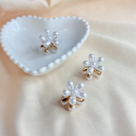 Mini piranha de cabelo dourada em formato de flor, com pétalas em pérola. Ideal para prender pequenas mechas e criar penteados delicados.